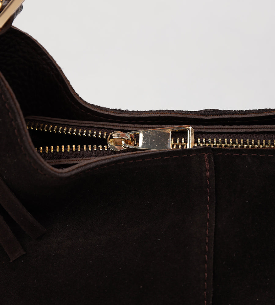 Suede bag with fringed edges and a gold handle