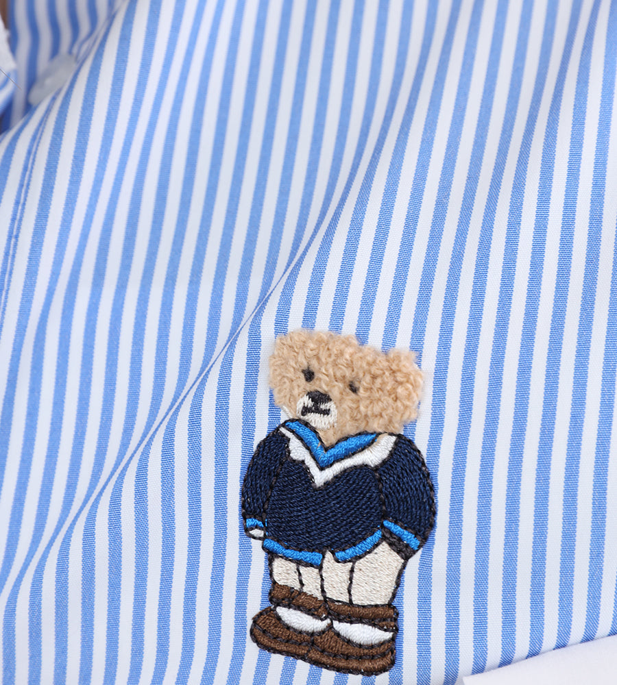 A striped white collared shirt with a teddy bear on the front