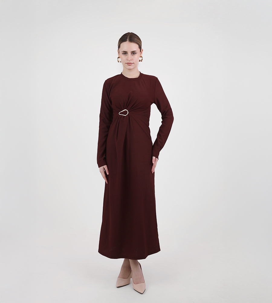 Long-sleeved dress with a brooch at the waist
