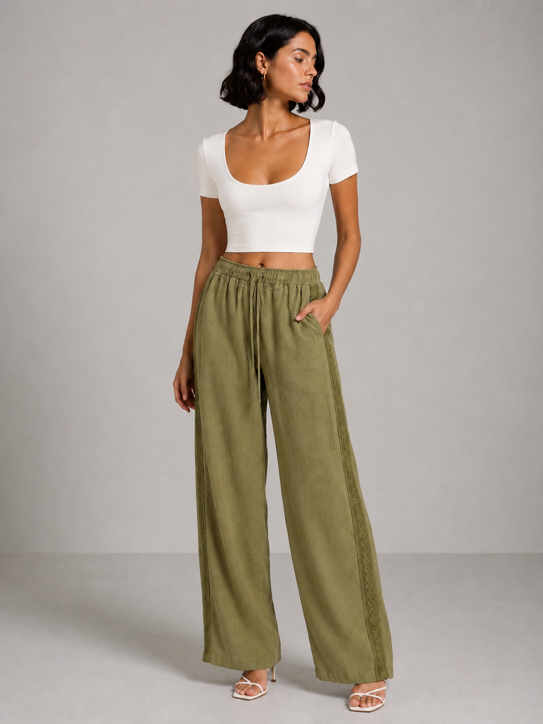 Olive green linen trousers with embroidery on both sides.