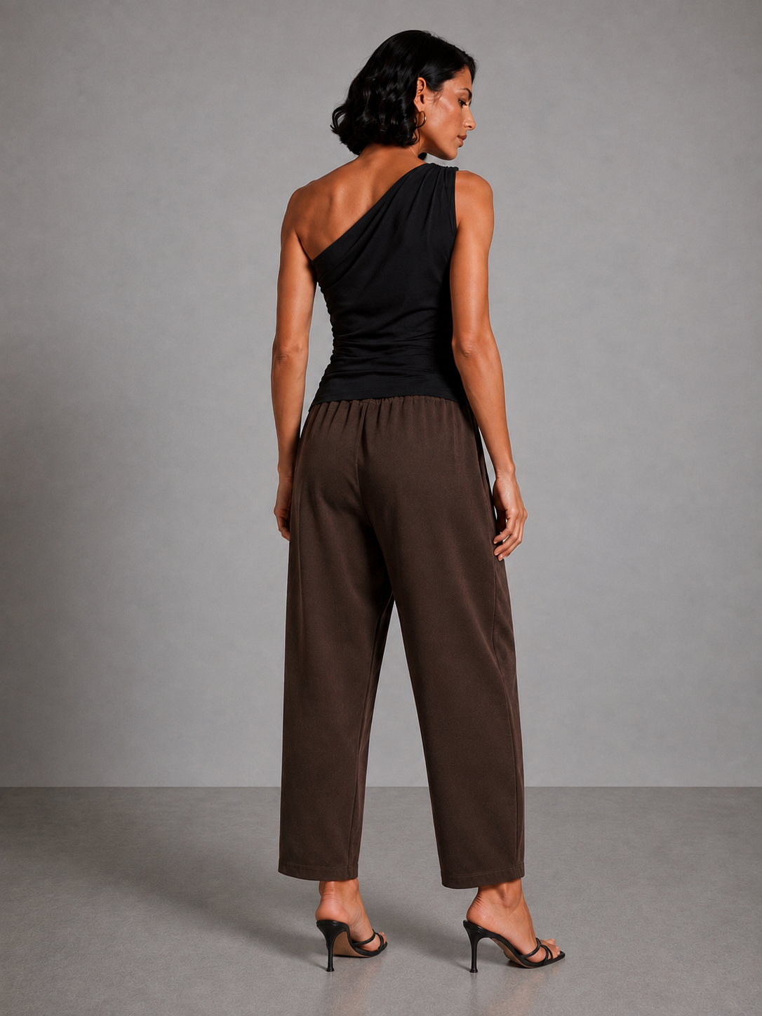 Brown trousers with gathered cuffs, a belt, and a side patch.