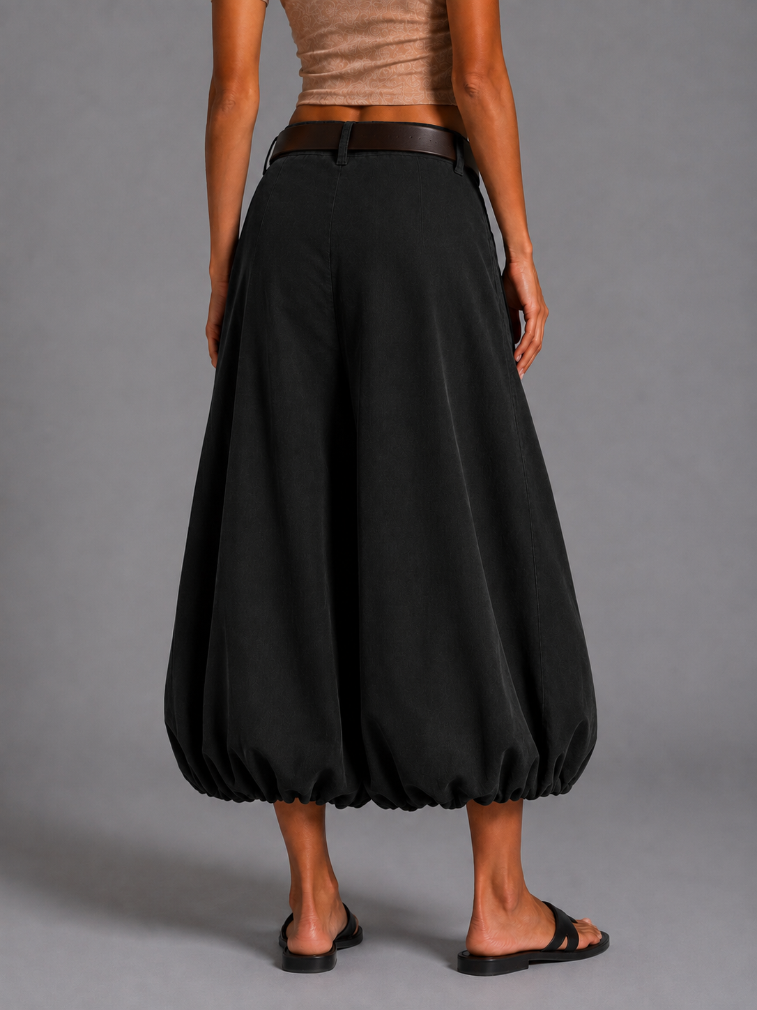 Long black corduroy skirt with a brown belt.