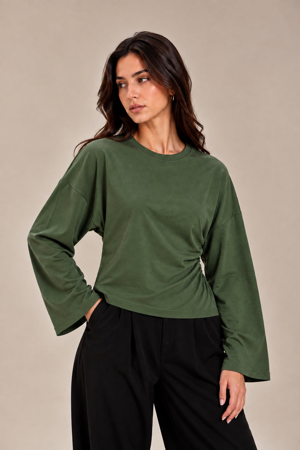 A blouse with wide sleeves and a gathered waist at the side.