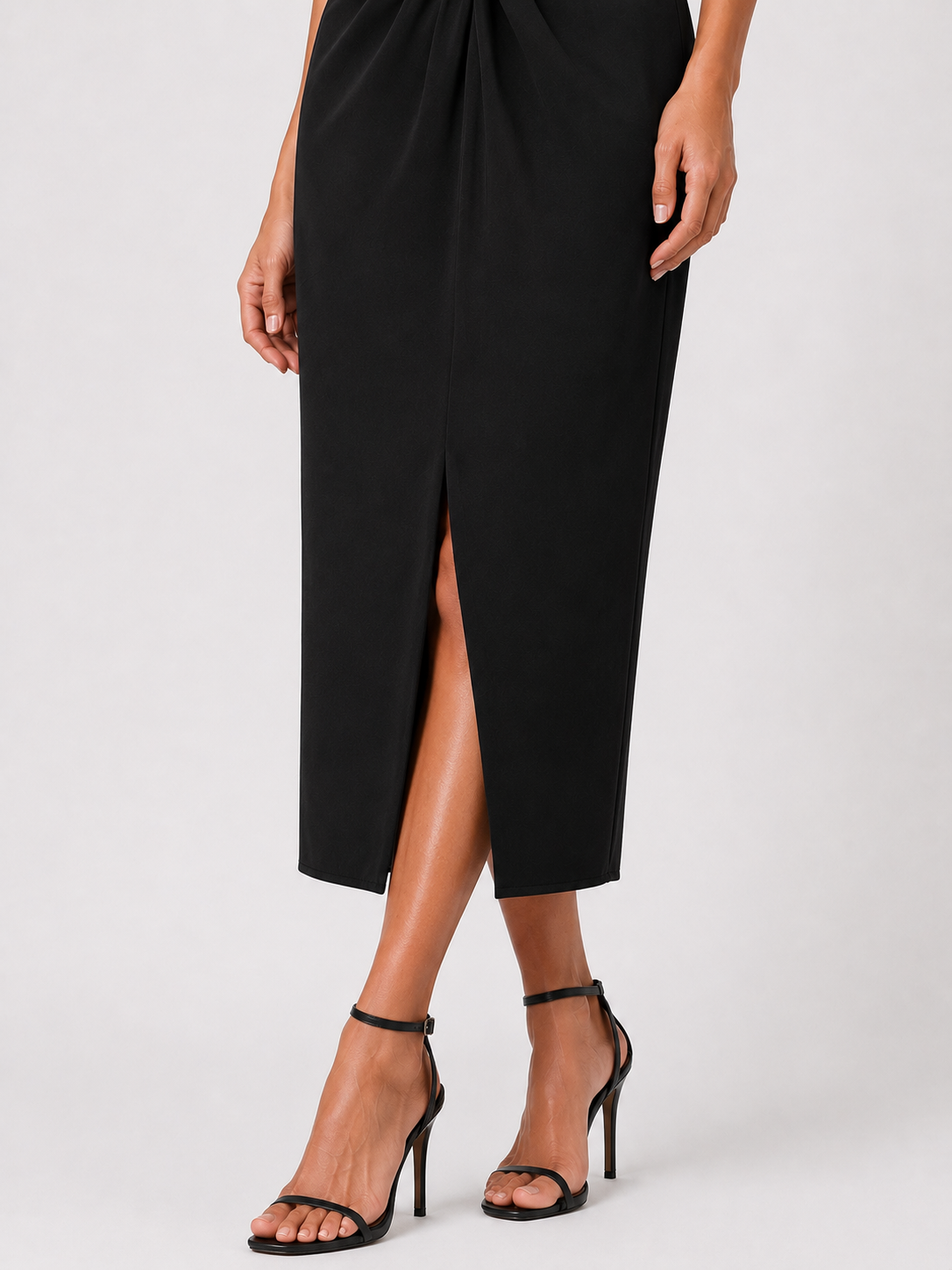 Long black V-neck dress with a gold brooch.
