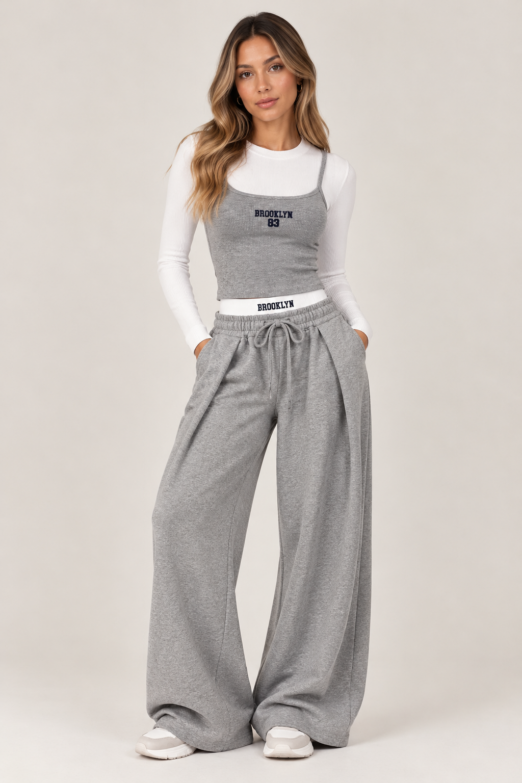 Wide leg sweatpants with an elasticated waistband, gray with a white waistband and the words "BROOKLYN83" in navy.
