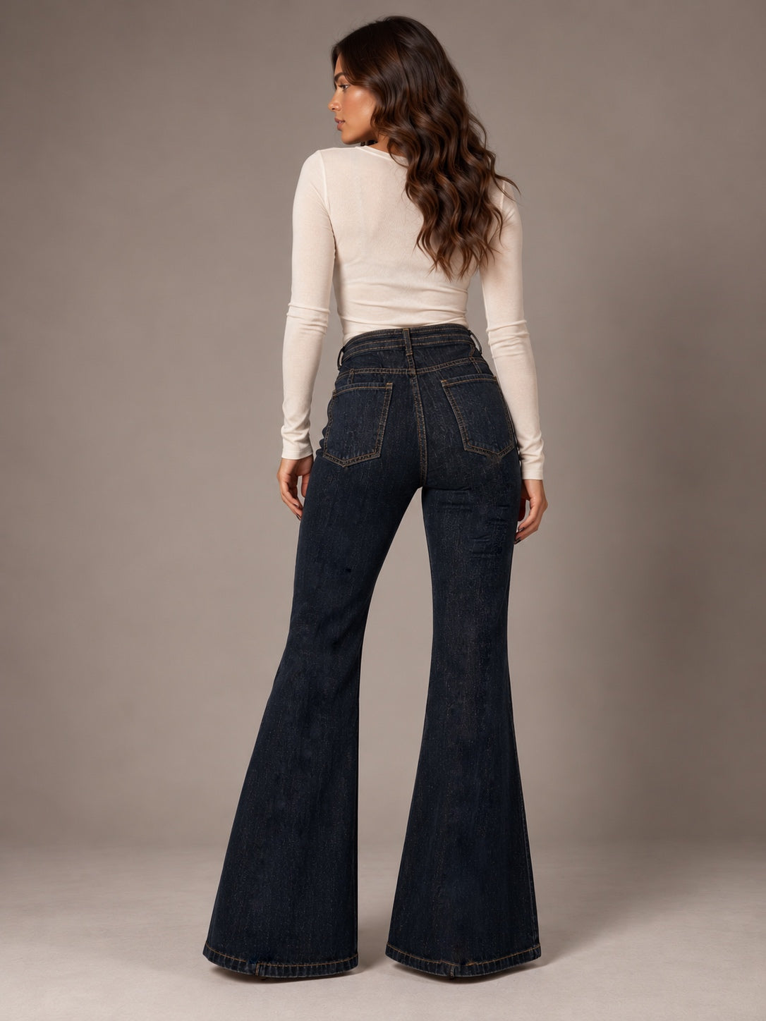 Dark navy blue flared jeans with a center seam, including a denim belt.
