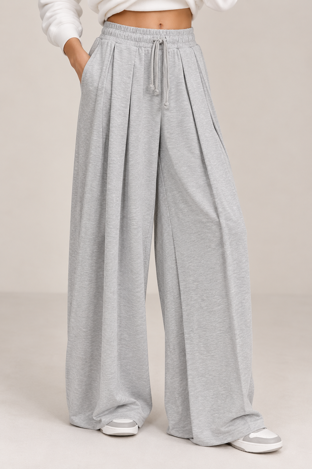 Wide-legged joggers, light gray, with a drawstring waist and pleated waistband.