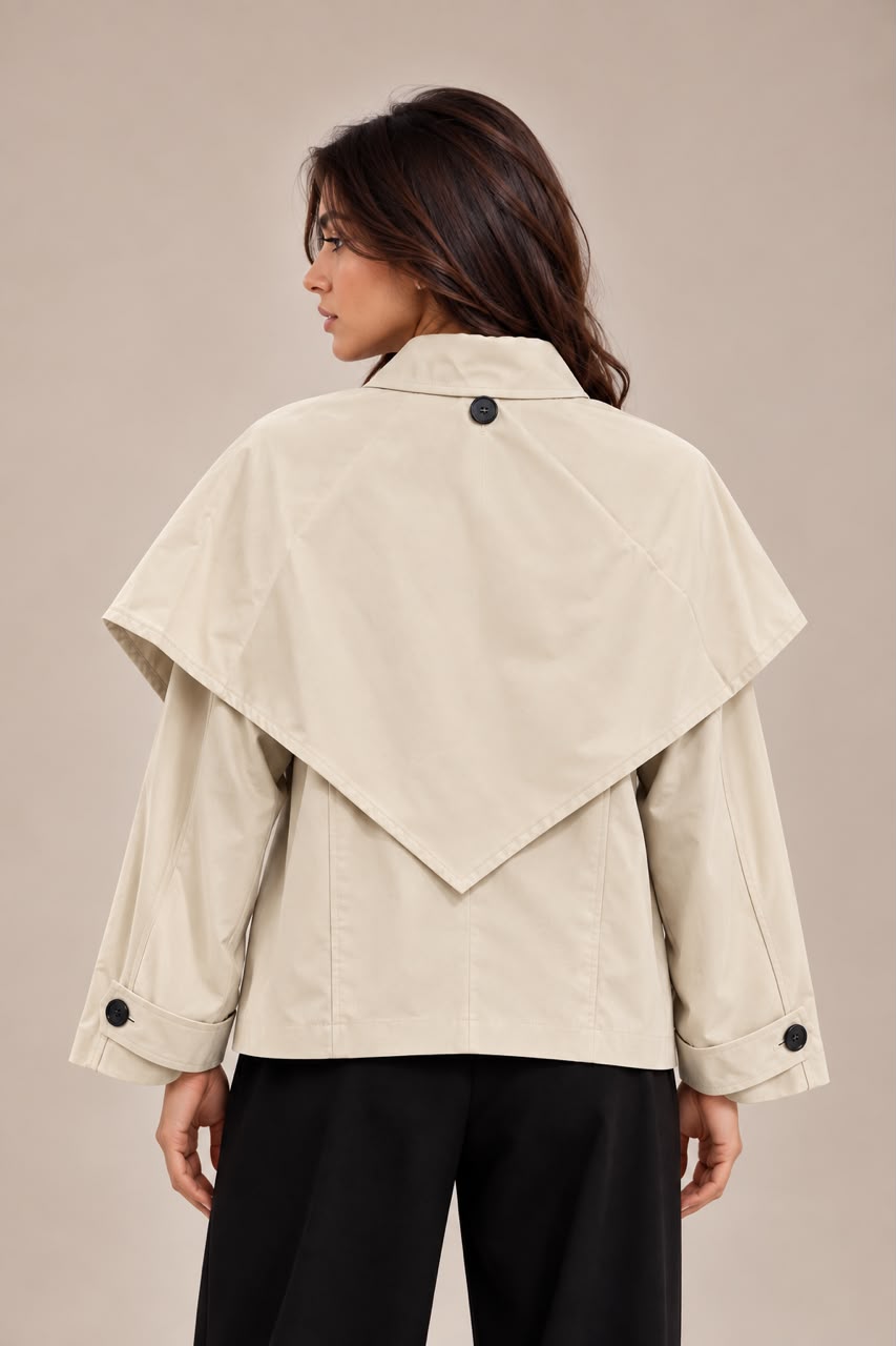 Short trench coat with detachable cape panel and buttons on the sleeves