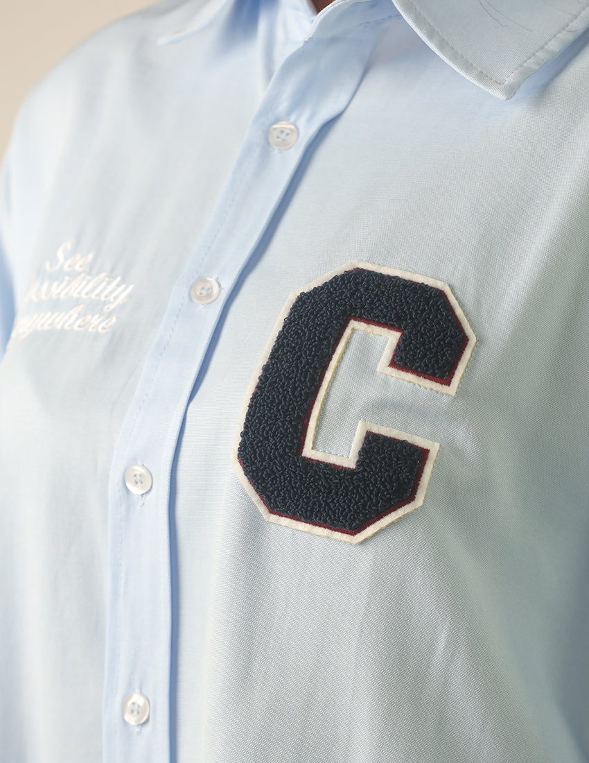 Oversized light blue shirt with the word "C" printed on it