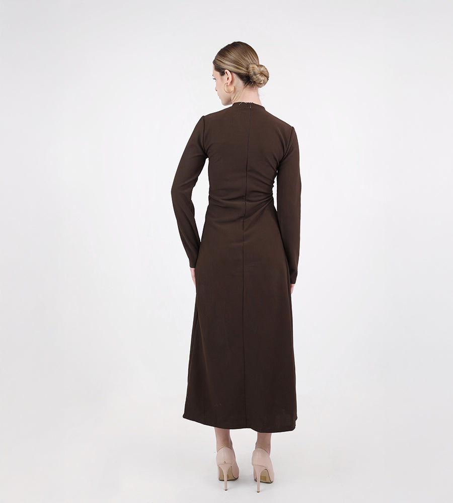 Long-sleeved dress with a brooch at the waist
