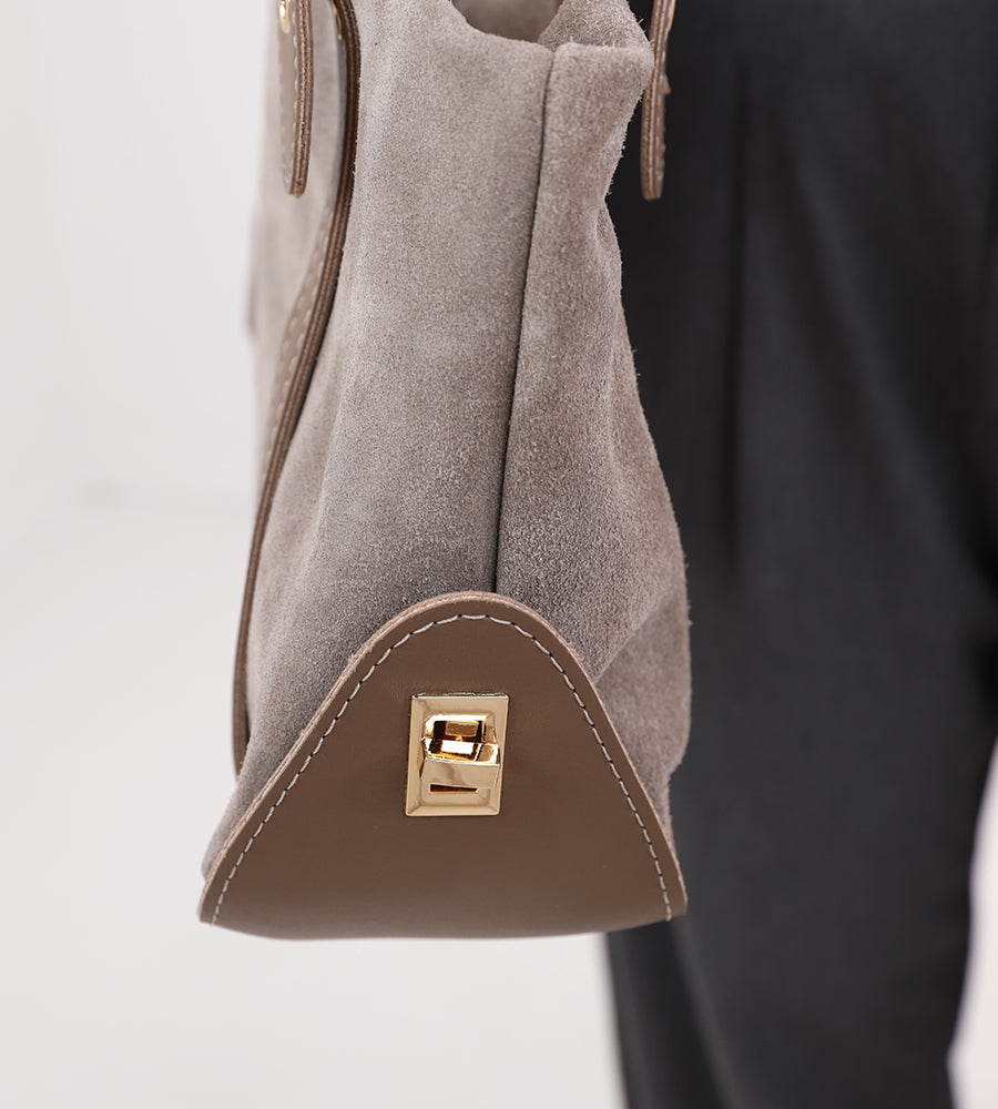 Rectangular suede handbag with a leather strap and gold accents.
