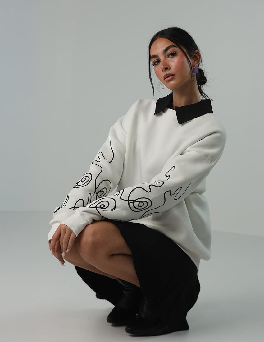 Oversized white blouse with a design on the sleeves