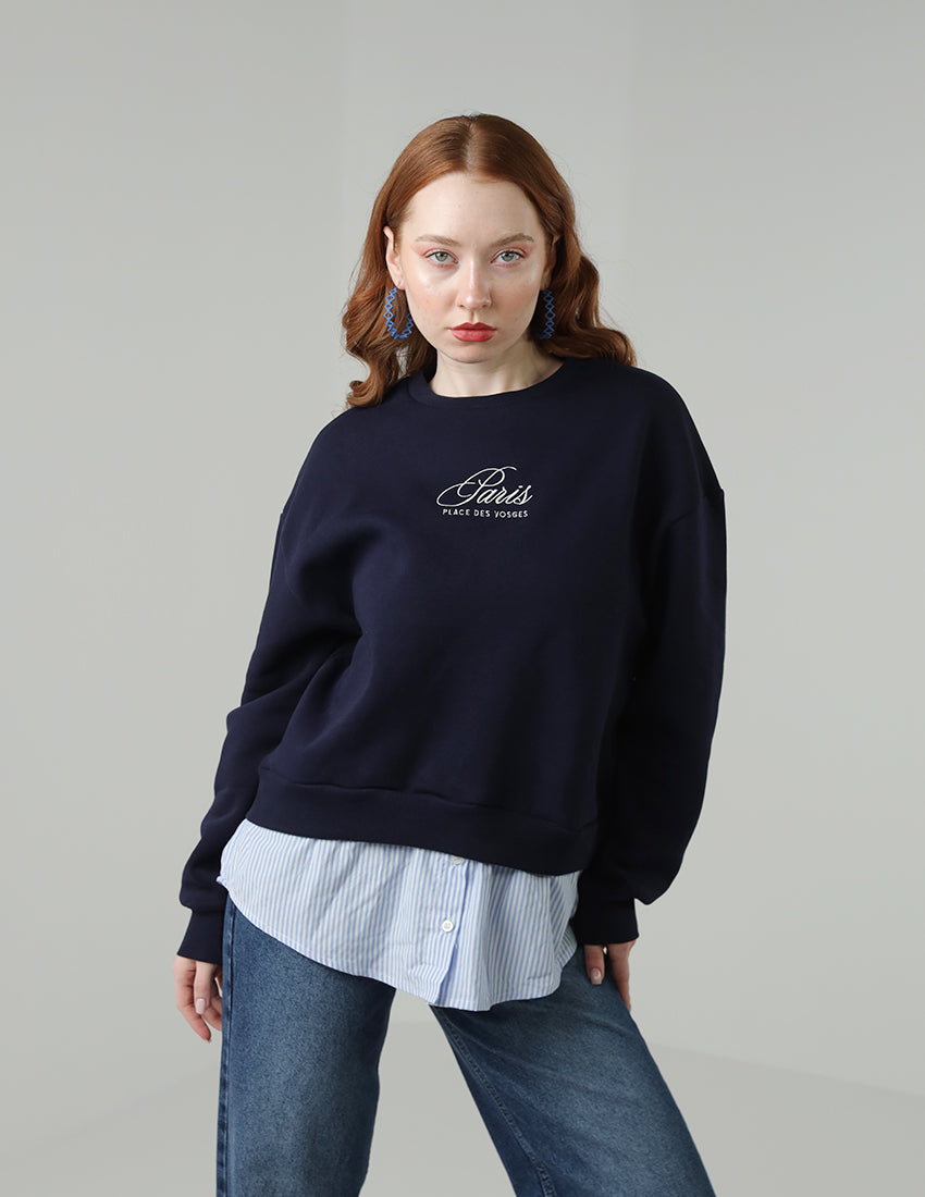 Navy blue blouse with the word "Paris" printed on it, worn with a shirt underneath.