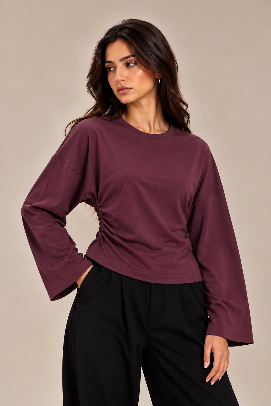 A blouse with wide sleeves and a gathered waist at the side.