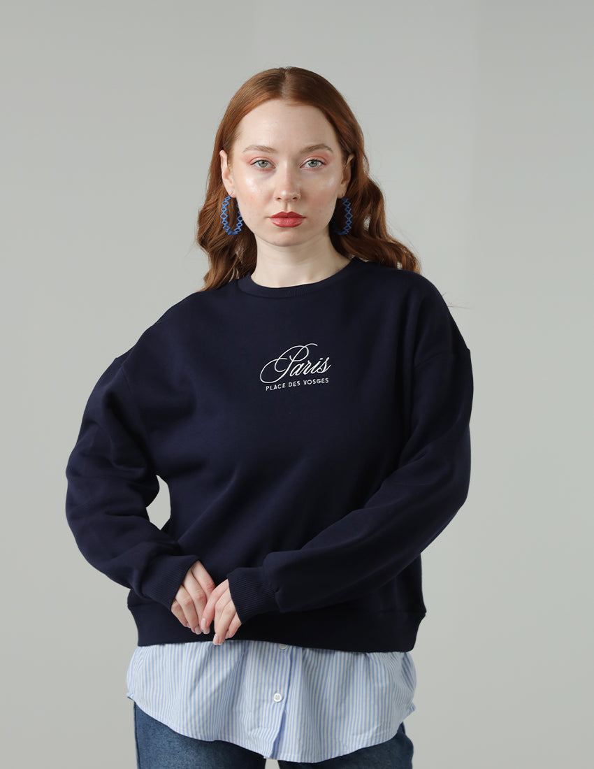 Navy blue blouse with the word "Paris" printed on it, worn with a shirt underneath.