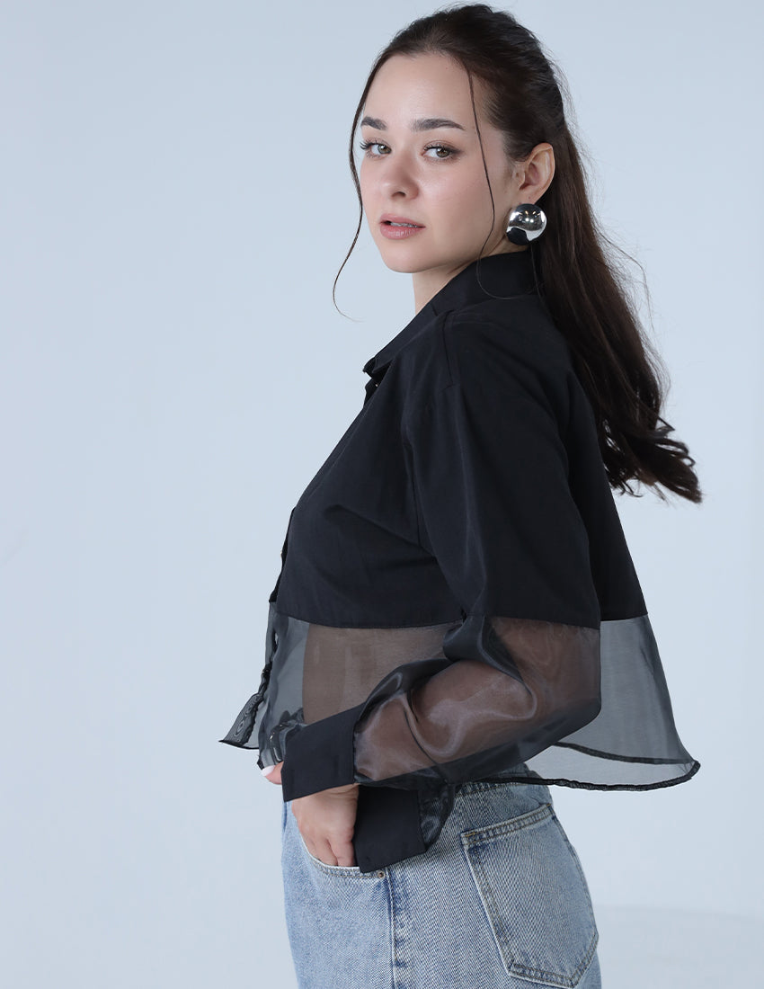 A black shirt with chiffon at the waist and golden heart-shaped buttons.