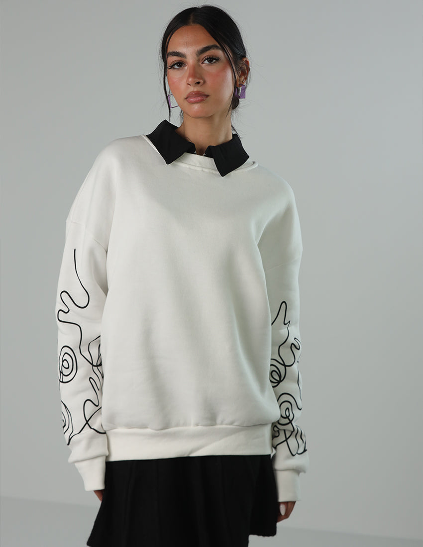 Oversized white blouse with a design on the sleeves