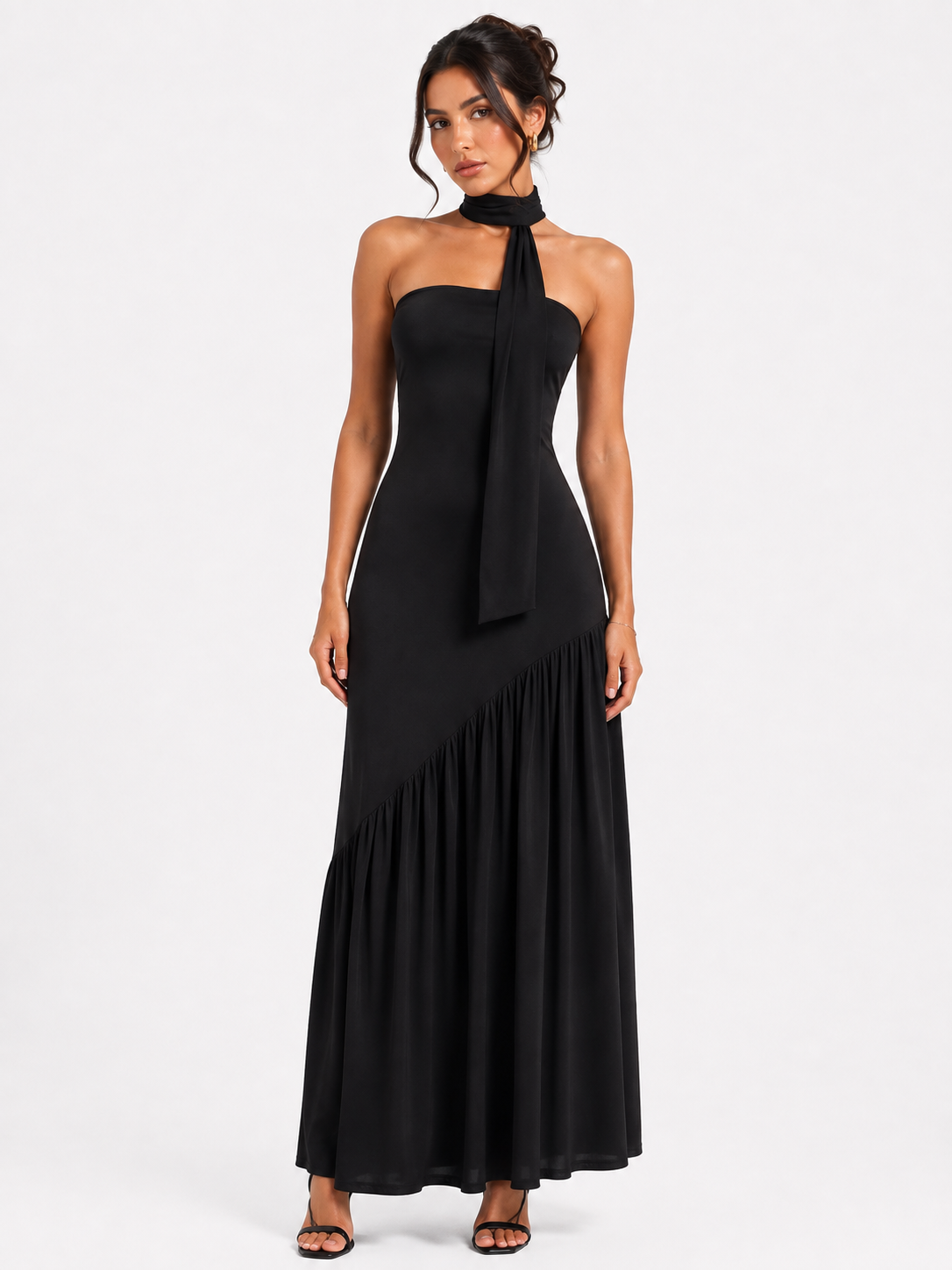 A long, backless dress featuring an asymmetrical waist, a front slit, and a neck tie.