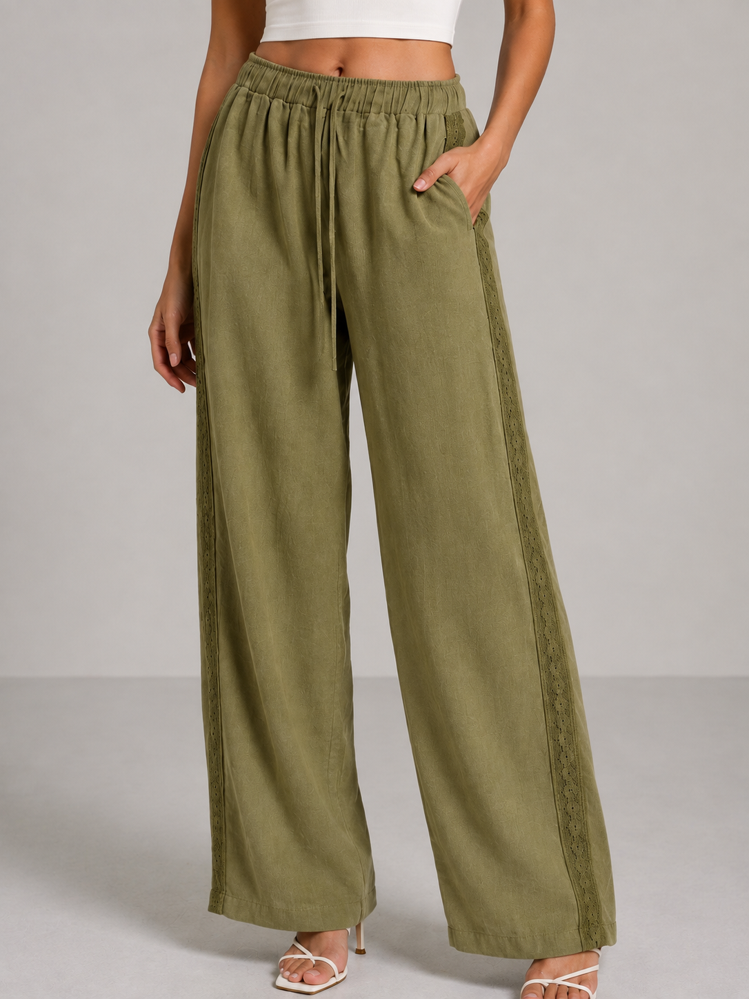 Olive green linen trousers with embroidery on both sides.