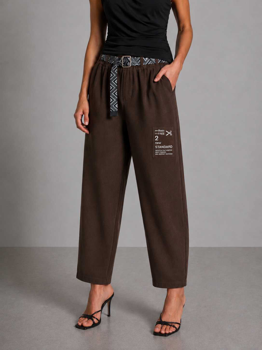 Brown trousers with gathered cuffs, a belt, and a side patch.
