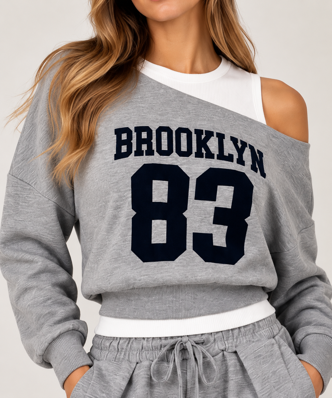 A gray blouse with a white off-the-shoulder top featuring the words "BROOKLYN83" in navy blue on the chest.
