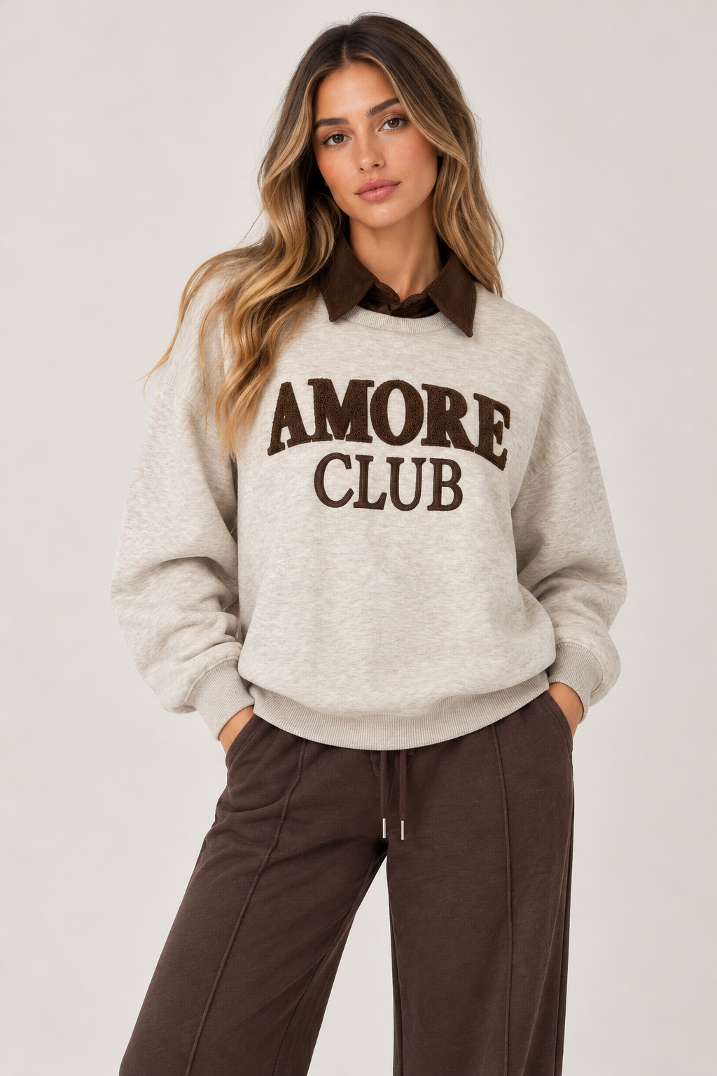 Oversized beige blouse with a brown suede shirt collar and the words "AMORE CLUB" written on the chest in brown.