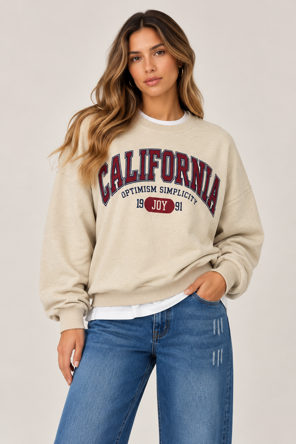 Oversized beige blouse with a white collar and waistband, and the word "CALIFORNIA" written on the chest in burgundy.