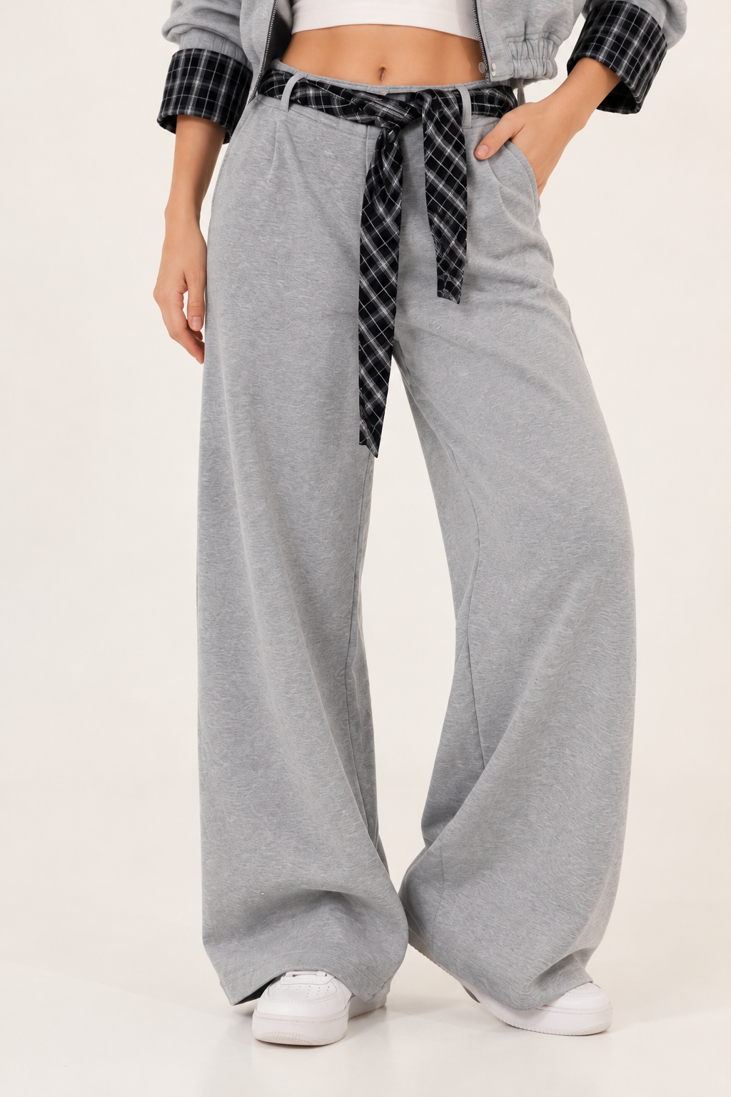 Gray straight-cut trousers with a black plaid scarf at the waist