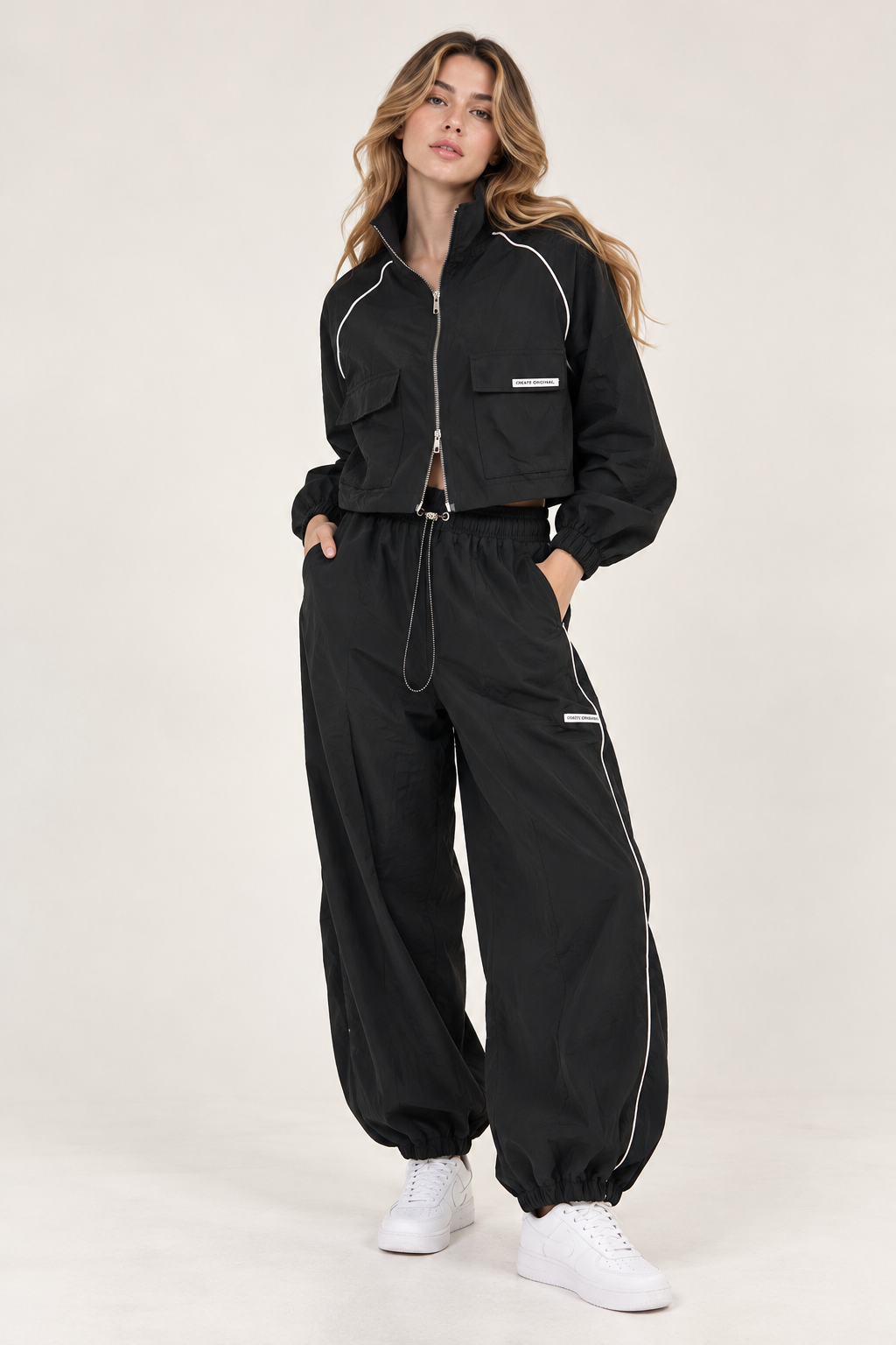 Wide black waterproof pants with a white stripe down the sides, gathered at the leg and waist.