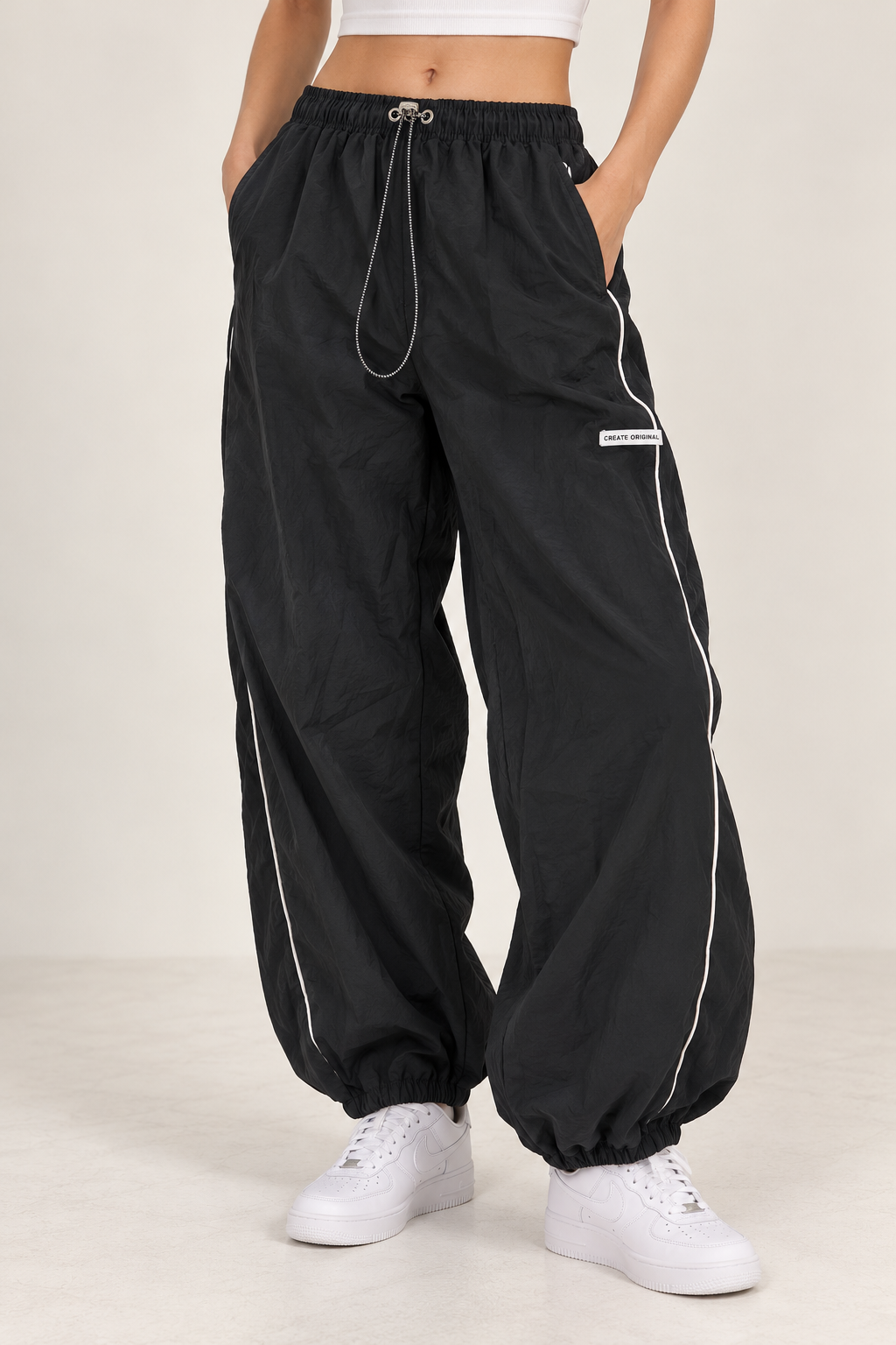 Wide black waterproof pants with a white stripe down the sides, gathered at the leg and waist.
