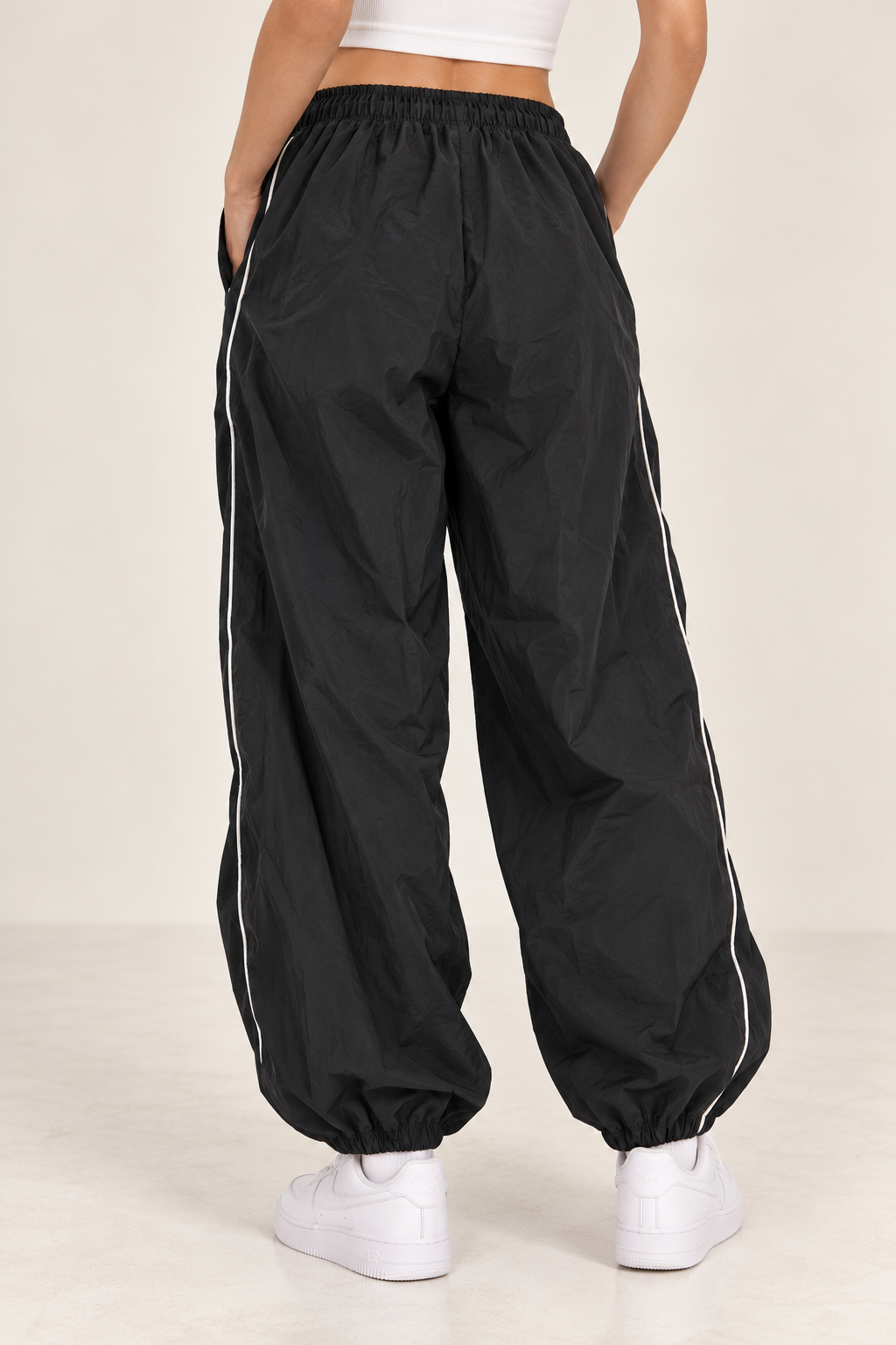 Wide black waterproof pants with a white stripe down the sides, gathered at the leg and waist.