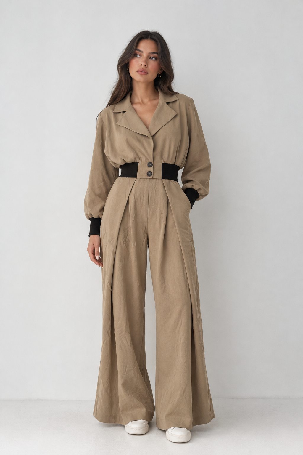 Beige short jacket with a brown elastic waist and button placket.